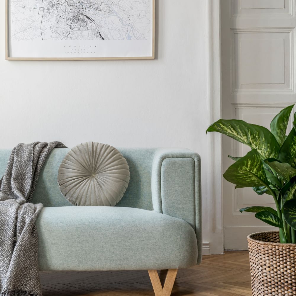 Groene bank, rond kussen, grijs kleed, naturel inrichting, Scandinavisch, visgraatvloer, lichte woonkamer, klassiek interieur