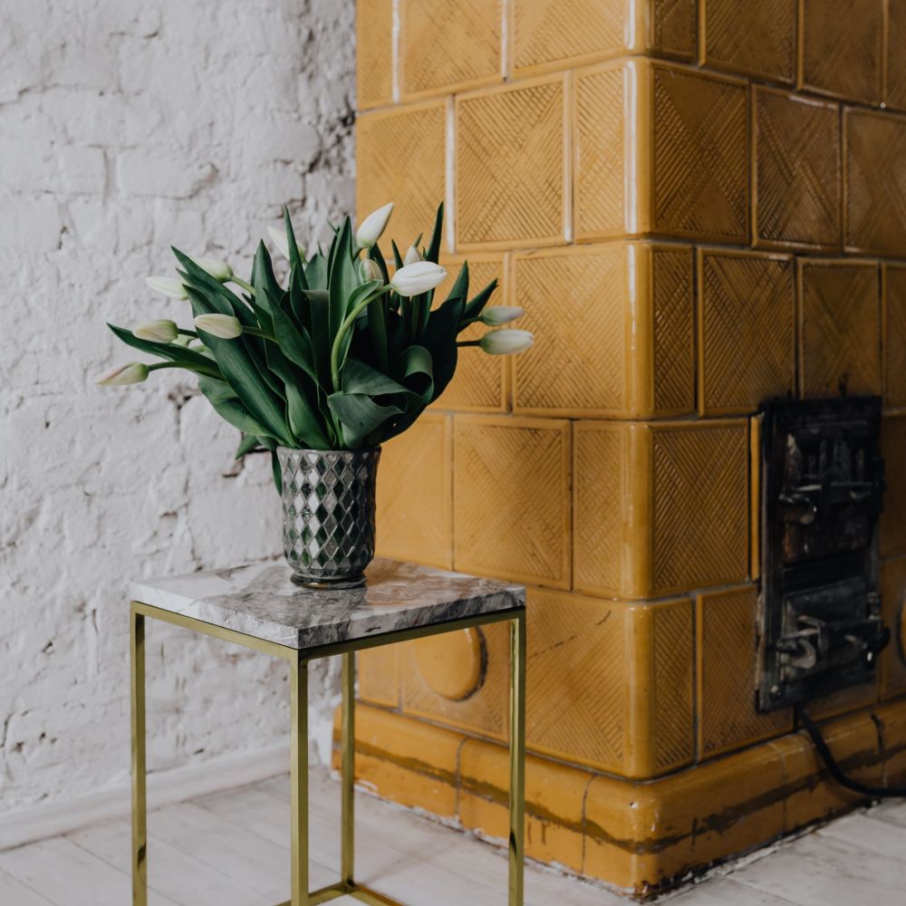 Gele tegels op haard messing bijzettafel geel inrichting geel in woonkamer open haard met geel